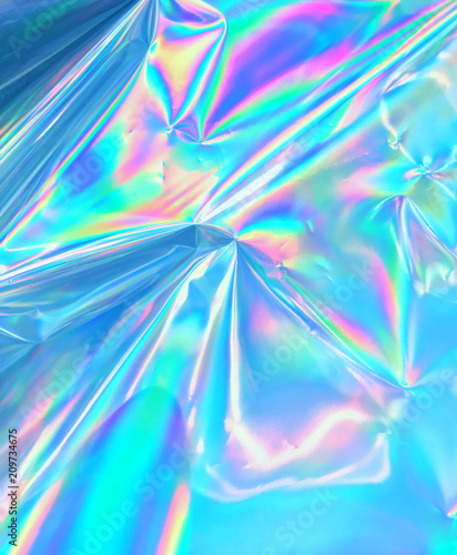 Holographic neon color iridescent wrinkled foil surface.