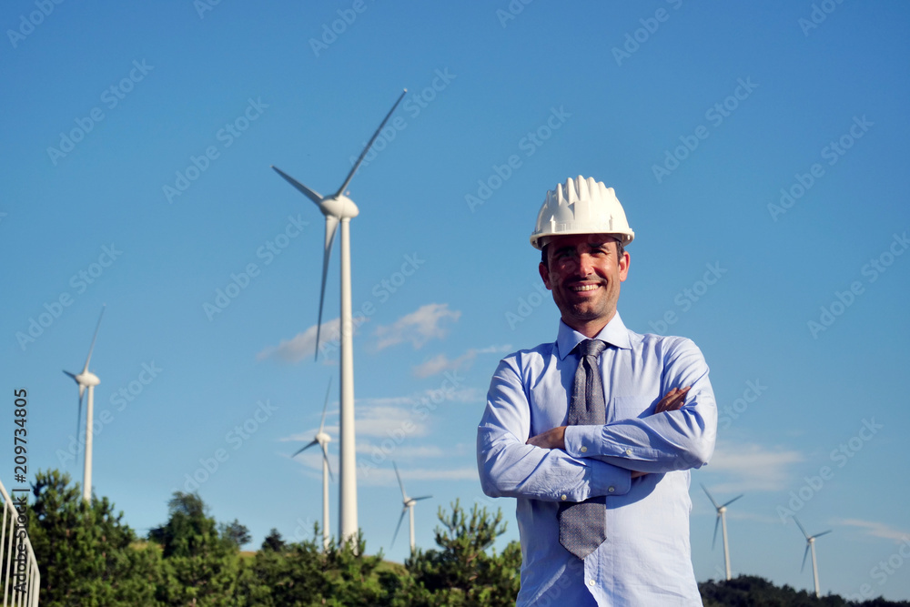 Portrait an engineer controls the functioning of wind turbines that run thanks to the force of the wind and generate electricity sustainably to the planet. Concept of: renewable energy Portrait an engineer controls the functioning of wind turbines that run thanks to the force of the wind and generate electricity sustainably to the planet. Concept of: renewable energy