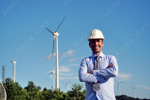Portrait an engineer controls the functioning of wind turbines that run thanks to the force of the wind and generate electricity sustainably to the planet. Concept of: renewable energy © Kitreel