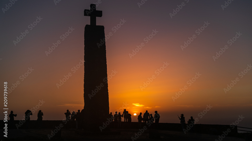 Cross at Cape Roca, Cabo da Roca with silhouettes and sunset, Portugal.