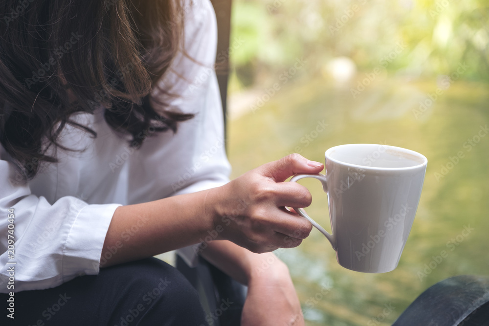 Closeup image of a woman holding a coffee cup before drinking in the morning Closeup image of a woman holding a coffee cup before drinking in the morning