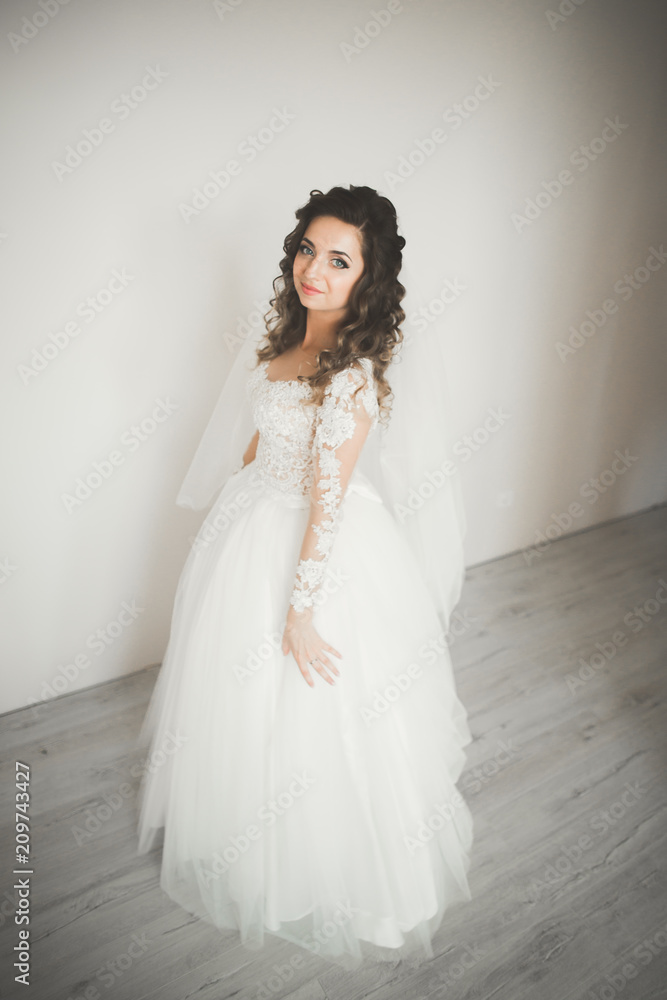 Fototapeta premium Luxury bride in white dress posing while preparing for the wedding ceremony