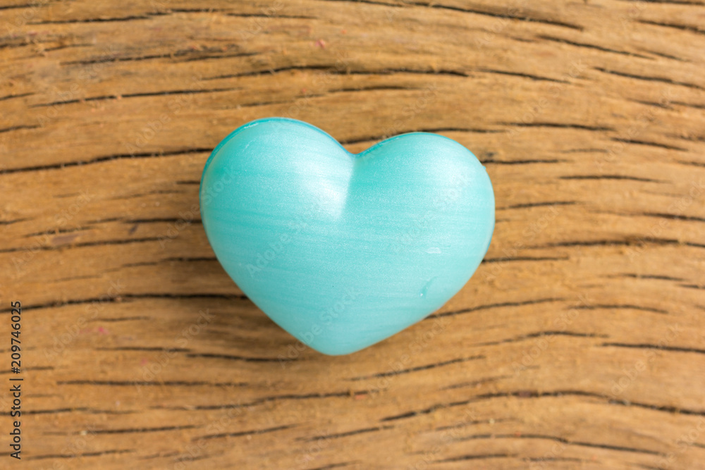 Blue heart shape over wooden table. Symbol of valentine day for background use. Concept of love and romance.