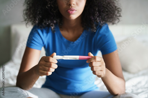 Sad Young Woman With Pregnancy Test At Home photo