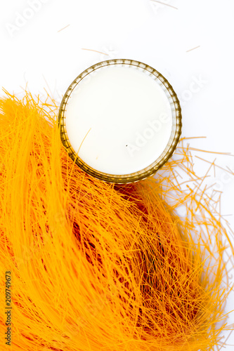 Close up of Raw vermicelli or sevee or seviyan or seviyaan isolated on white with a bowl of milk used to make kheer. photo