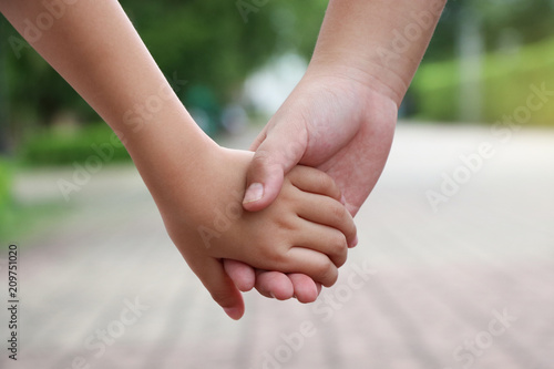 Childs hands holding together brother and sister take care and support parent concept © louisnina