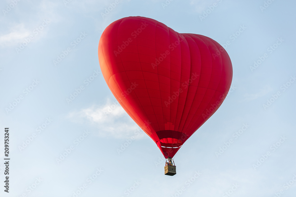 Naklejka Red hot air balloon in the shape of a heart fly in sky. Love, honeymoon and romantic travel concept