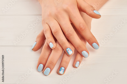 Female hands with winter manicure. Well-groomed woman hands with cute winter design manicure. Manicured hands close up.
