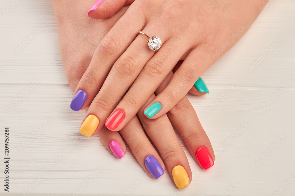 Ring with diamond on manicured hands. Hands of young woman with beautiful manicure and engagement ring. Female beauty and jewelry.