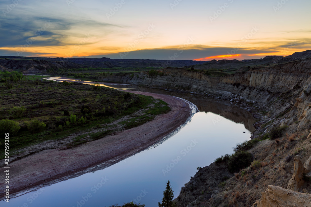 The sun sets over the LIttle Missouri River in Theodore Roosevelt National Park