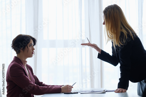 boss reproaching her employee. business woman getting a reprimand or reproof chief manager. superior and subordinate professional relationship. photo