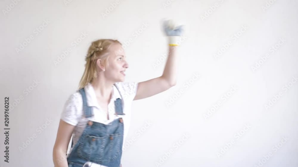 Young family makes repairs in new flat. Beautiful couple - painting wall in apartment. Man and woman doing overhaul of house. Guy and girl making decorate room, laughing and having fun. Young family makes repairs in new flat. Beautiful couple - painting wall in apartment. Man and woman doing overhaul of house. Guy and girl making decorate room, laughing and having fun.