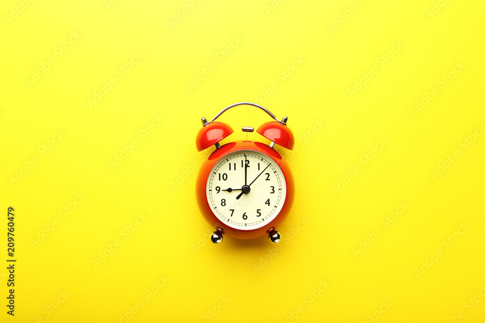 Red alarm clock on yellow background Red alarm clock on yellow background