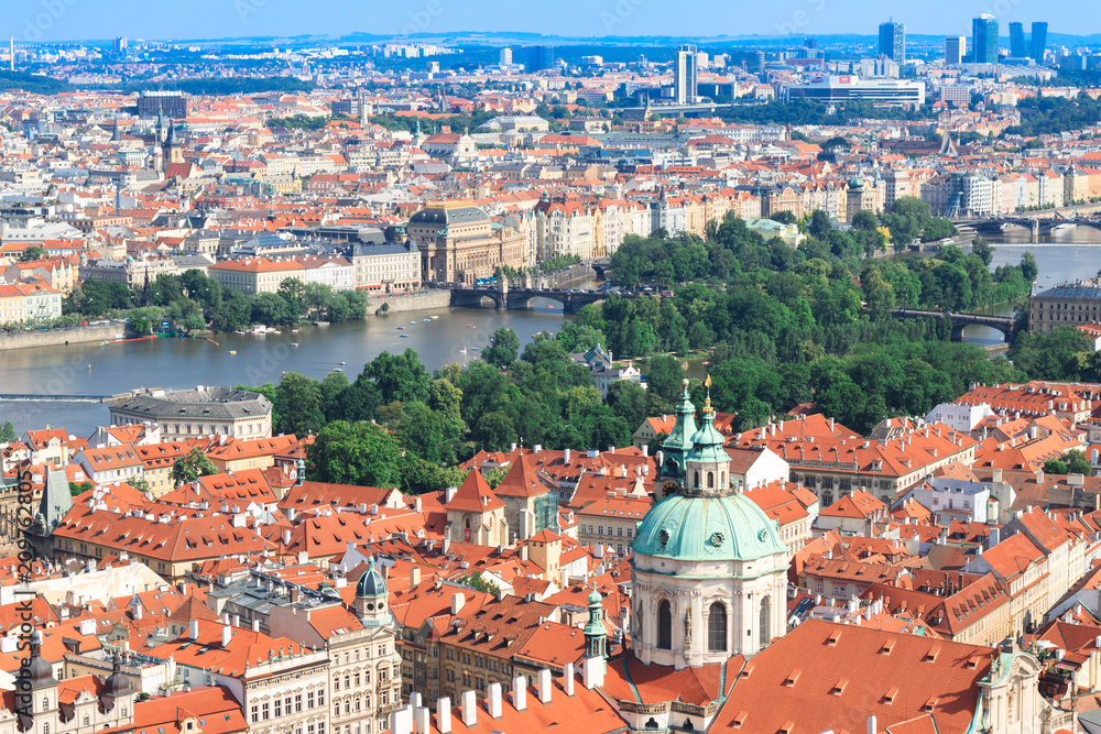 Beautiful and ancient city of Europe - Prague, Czech Republic. View of the city from the observation deck. Small houses and the river Vltava. Charles Bridge and temples.