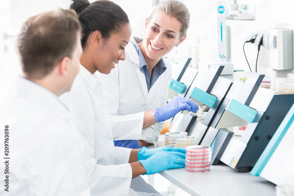 Group of researchers using scientific technology for test of germ samples Group of researchers using scientific technology for test of germ samples