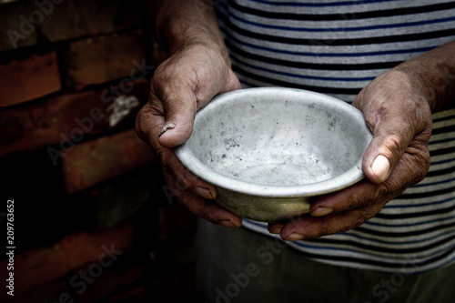 Foto The poor old man's hands hold an empty bowl