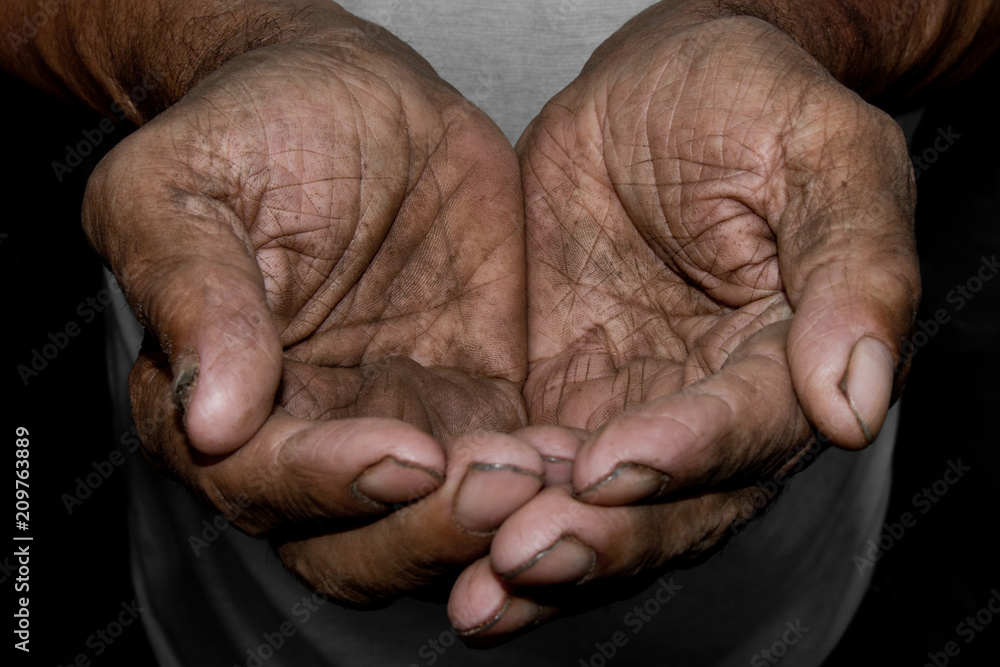 Fototapeta premium The poor old man's hands beg you for help. The concept of hunger or poverty. Selective focus.