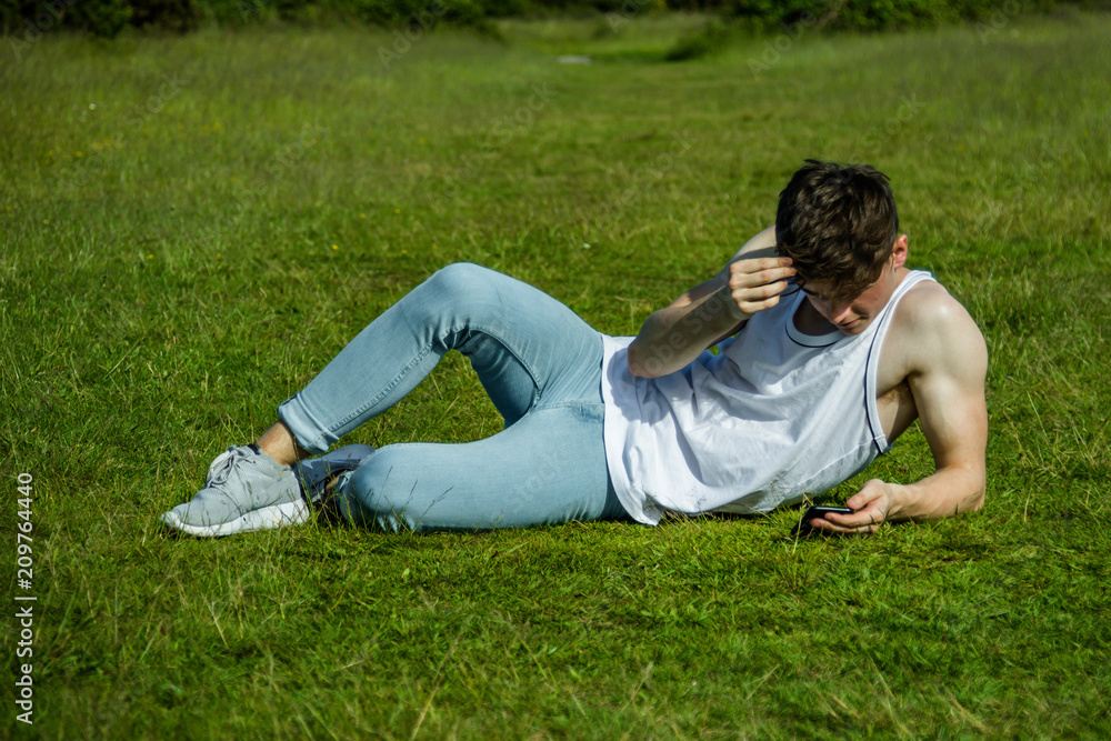 A young adult male sitting outside on a summer's day A young adult male sitting outside on a summer's day