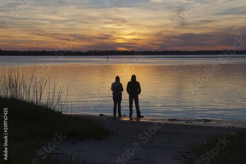 Mindful Couple Watch a Colorful Sunset Over the Bay