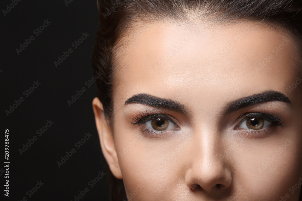 Young woman with beautiful eyebrows on black background Young woman with beautiful eyebrows on black background