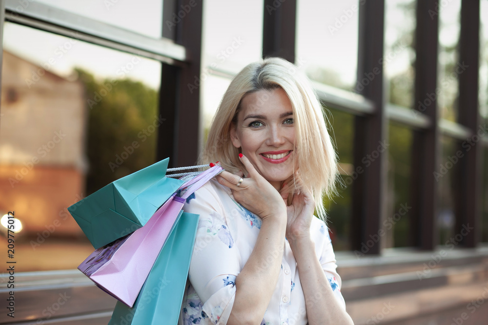 Beautiful woman in shopping. Happy woman with shopping bags enjoying in shopping. Consumerism, shopping, lifestyle concept Beautiful woman in shopping. Happy woman with shopping bags enjoying in shopping. Consumerism, shopping, lifestyle concept