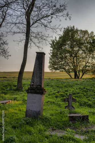 Some tombstones in an old abandoned and forgotten cemetery in Alsobikol, Hungary photo