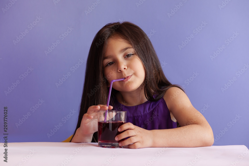 Cute little brunette girl drinking fresh juice Cute little brunette girl drinking fresh juice