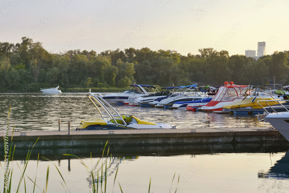 Obraz premium Floating crafts on the mooring berth for summer weekend or vacation. Dnieper River, Ukraine.