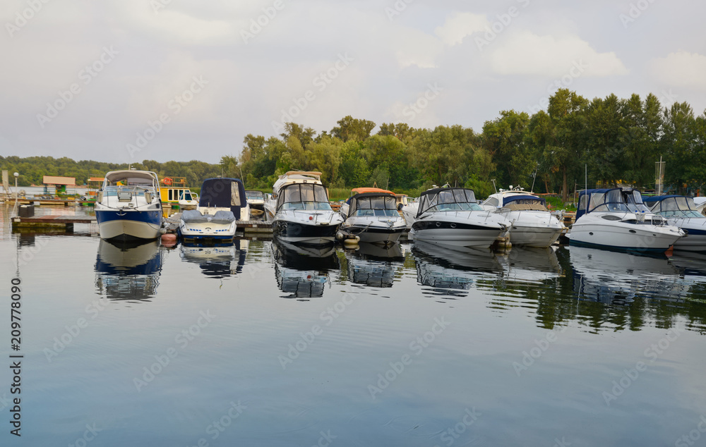 Floating crafts on the mooring berth for summer weekend or vacation. Dnieper River, Ukraine. Floating crafts on the mooring berth for summer weekend or vacation. Dnieper River, Ukraine.