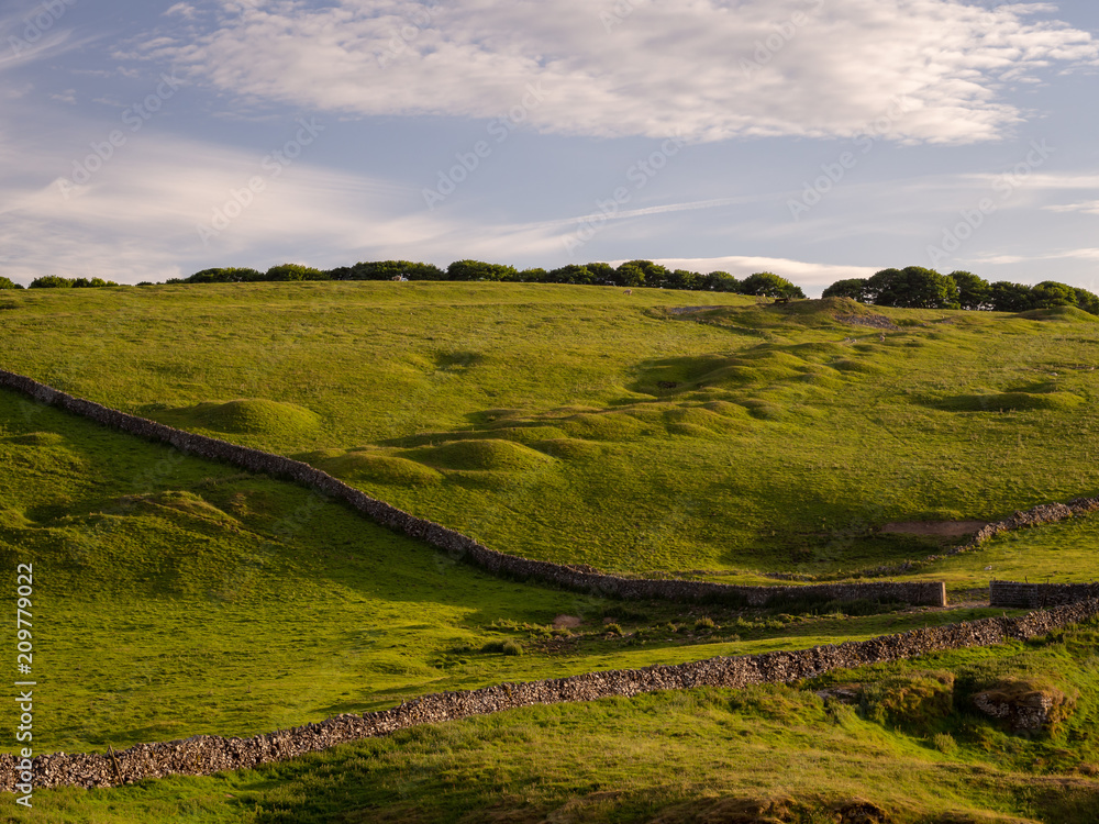 Hilly landscape in the peak district of great britain with stone fences