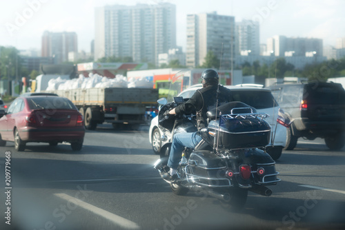 biker in helmet on big black bike on road with traffic