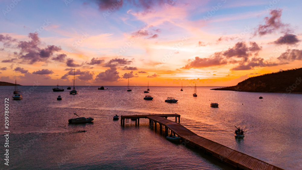 Tropical Sunset over Ocean Pier with Boats