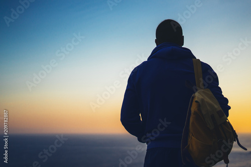 Hipster hiker tourist looking of amazing seascape sunset on background sea, guy enjoying ocean horizon, panoramic sunrise, traveler relax holiday concept, sunlight view in trip vacation