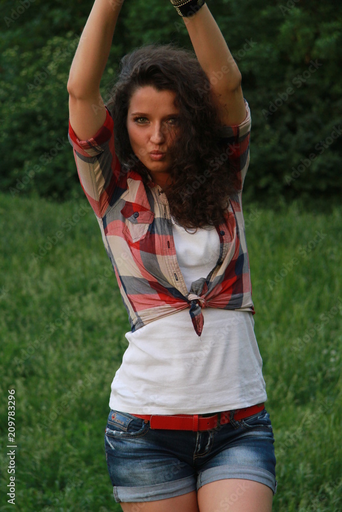 Young woman with dark curly hair. Young woman in the nature. Young woman with dark curly hair. Young woman in the nature.