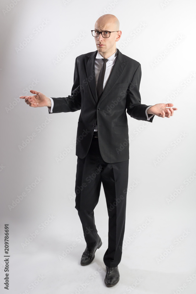 Full length portrait of a slim tall bald man in a black suit with black tie  with his arms apart. The expression of question and bewilderment. White  background. Photos | Adobe Stock