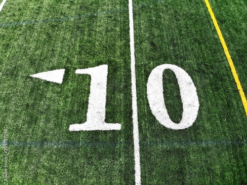 10 yard chalk mark on an green American football field taken from an aerial drone