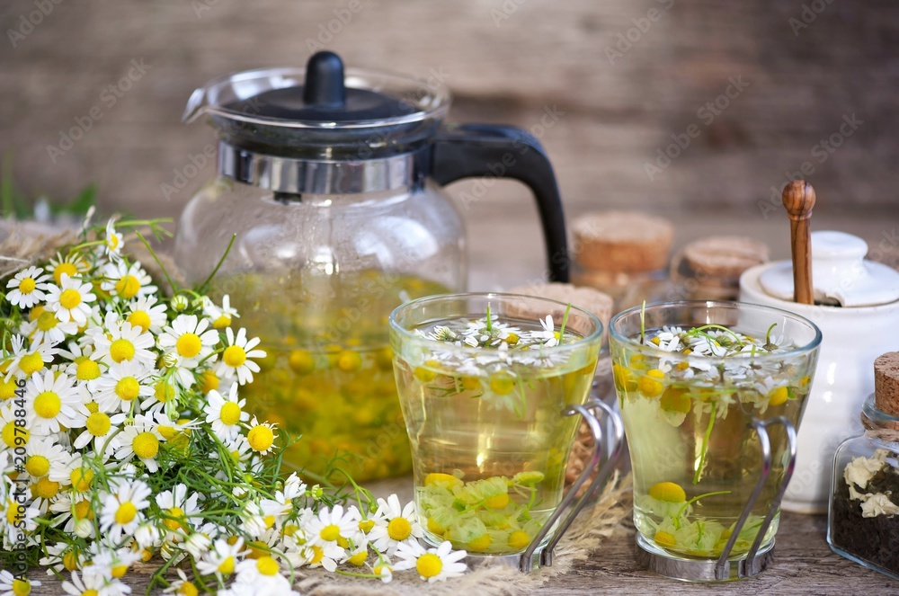 cup of chamomile tea with chamomile flowers on wooden planks cup of chamomile tea with chamomile flowers on wooden planks