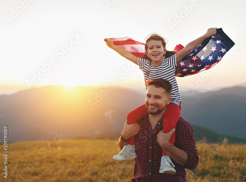  happy family father and child with flag of united states enjoying sunset on nature
 photo