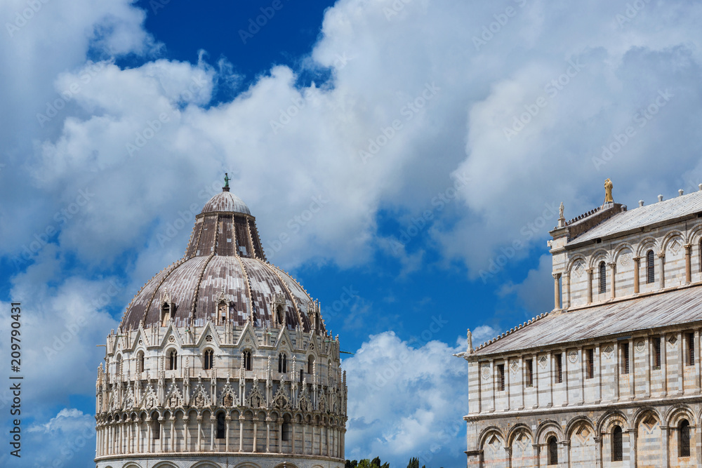 Square of Miracles landmarks: Pisa Cathedral and gothic Baptistry dome, among beautiful clouds. Unesco Wolrld Heritage