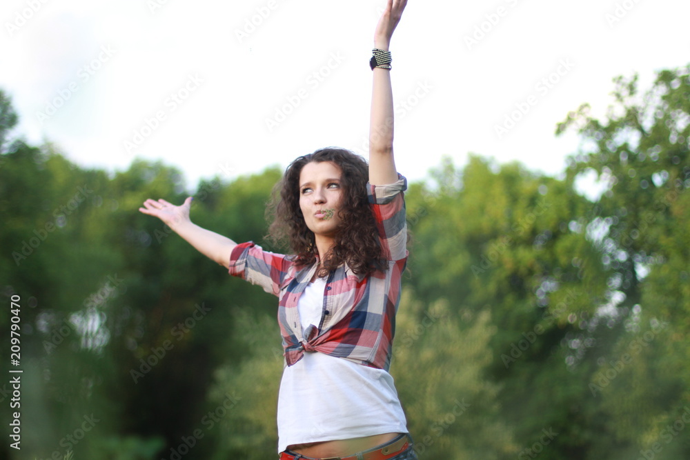 Young, beautiful woman on nature. Young woman with dark curly hair. Young, beautiful woman on nature. Young woman with dark curly hair.
