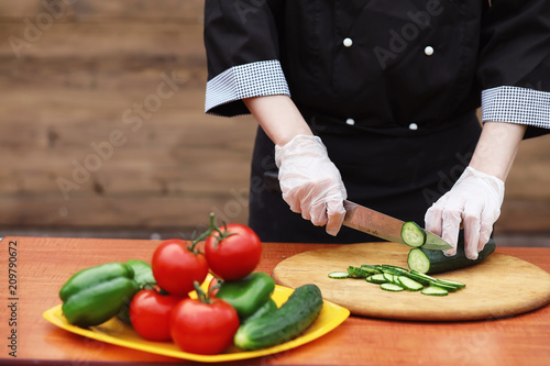 The cook cuts fresh farm vegetables