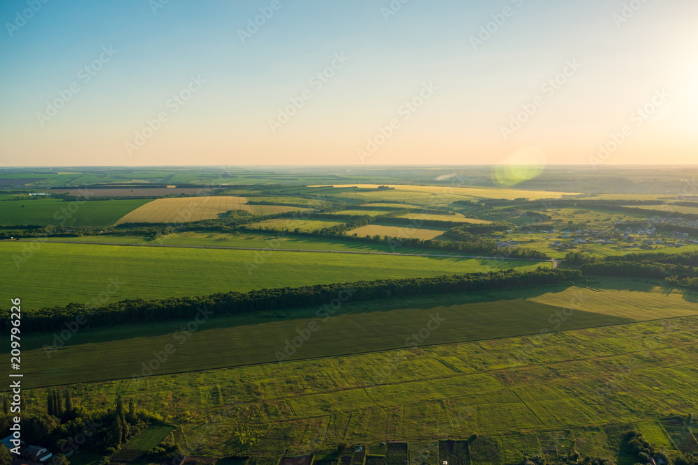 Fototapeta premium Top view, aerial photo from drone or aerostat to summer nature landscape panorama, green meadows in countryside at sunset time, beautiful travel background