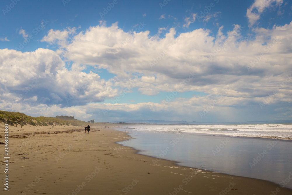 Peaceful walk along a sandy beach on a cloudy summer day