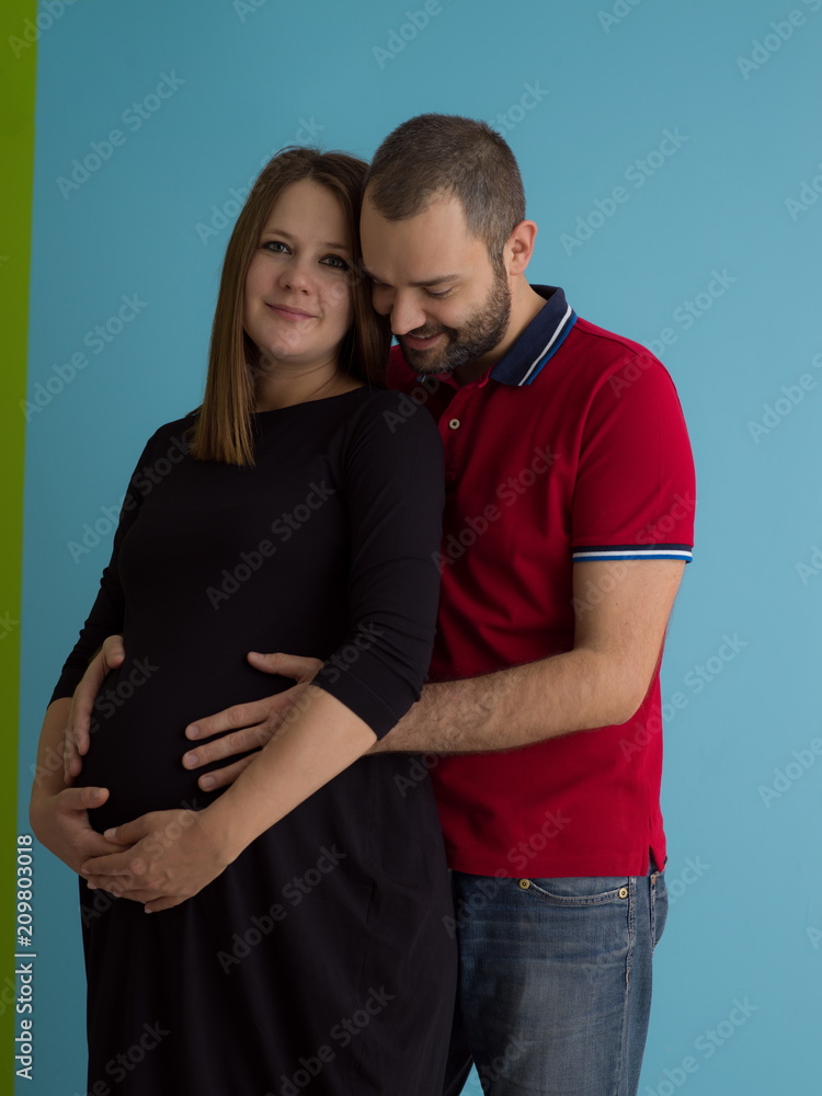 pregnant couple isolated over blue background pregnant couple isolated over blue background