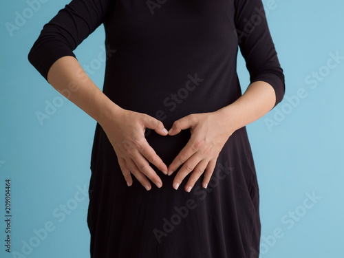Portrait of pregnant woman over blue background