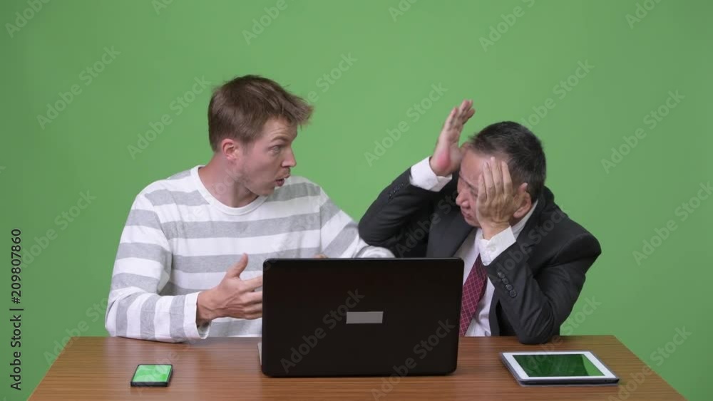 Mature Japanese businessman and young Scandinavian businessman working together Mature Japanese businessman and young Scandinavian businessman working together