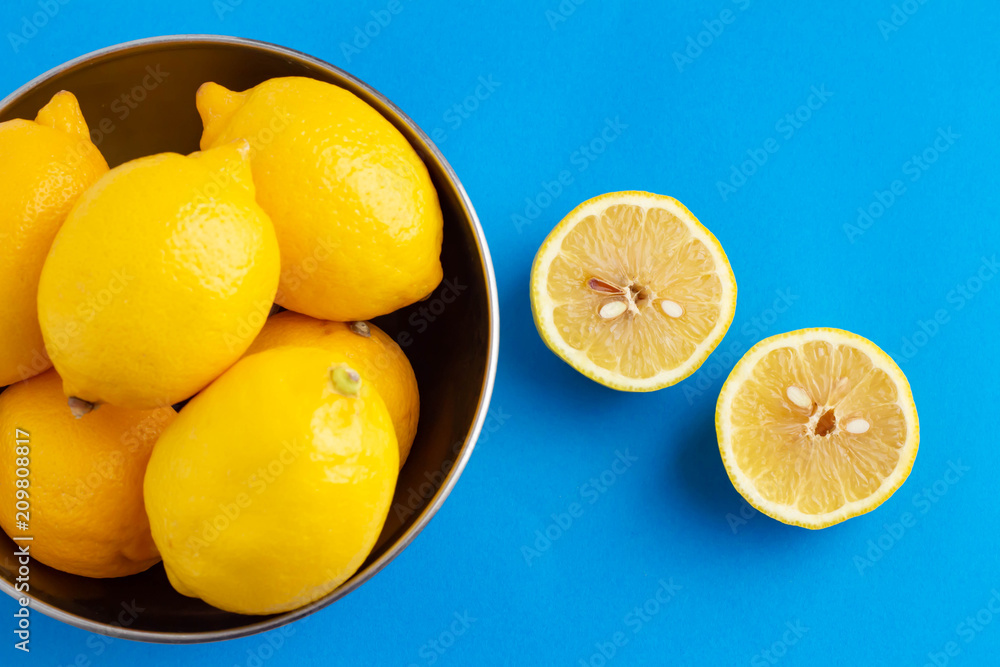青い背景にボールに入った黄色が鮮やかなレモン