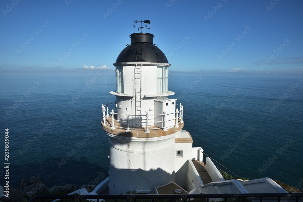 White lighthouse with a blue sky in a sunny day
