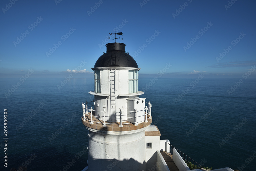 White lighthouse with a blue sky in a sunny day