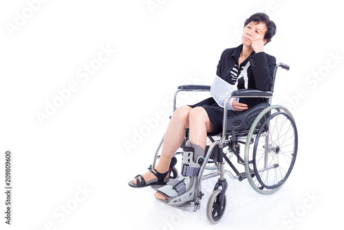 Asian businesswoman with broken arm and leg sitting on wheel chair over white background